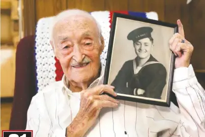  ?? STAFF PHOTO BY ERIN O. SMITH ?? Robert Rayburn poses with his Navy photo at his Chattanoog­a home on Oct. 15. Rayburn is a World War II Navy veteran and took part in several battles, including Leyte Gulf and the Battle of Midway.