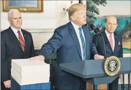  ?? Jim Lo Scalzo EPA/Shuttersto­ck ?? PRESIDENT TRUMP, with Vice President Mike Pence and Commerce Secretary Wilbur Ross, speaks after signing a spending bill last month in Washington.