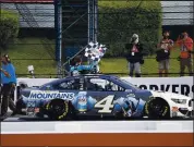  ?? MATT SLOCUM – THE ASSOCIATED PRESS ?? Kevin Harvick waves a checkered flag after winning the NASCAR Cup Series race at Pocono Raceway on Saturday.