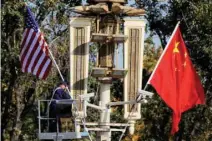  ?? — Reuters file photo ?? A worker places US and China flags near the Forbidden City ahead of a visit by US President Donald Trump to Beijing, in Beijing, China.