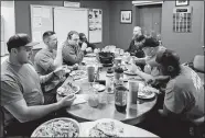  ?? SPENSER HASAK/THE DAILY ITEM OF LYNN VIA AP ?? In this Feb. 21 photo, Saugus firefighte­rs gather around the table to share an Italian meal at the Hamilton Street station in Saugus, Mass.