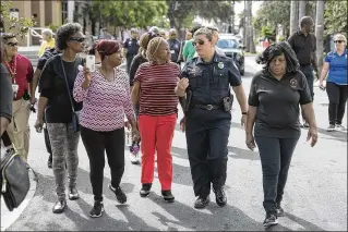  ?? PHOTOS BY ANDRES LEIVA / THE PALM BEACH POST ?? West Palm Beach Police Chief Sarah Mooney speaks with Sharon Engram (from far left), Cynthia Harris, and Lydia Hightower Friday during a walk organized by the Police Department along North Sapodilla Avenue. The neighborho­od has seen a rash of shootings...