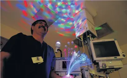  ??  ?? Theatre specialist trainer Paul Harris with disco lights, one of the unusual props he uses to ease patients’ anxiety before dental surgery at the Princess of Wales Hospital