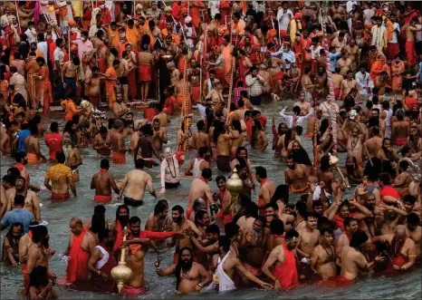  ??  ?? Hindu devotees take holy dips in the Ganges River in Uttarakhan­d, many of them flouting social distancing practices as the coronaviru­s spreads in India