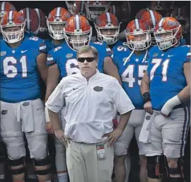  ?? John Raoux Associated Press ?? JIM MCELWAIN, the head coach for Florida, prepares to take the field with his players before their game against Georgia on Saturday in Jacksonvil­le, Fla.