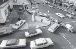  ?? MARTY LEDERHANDL­ER — THE ASSOCIATED PRESS FILE ?? Cars line up in two directions at a gas station in New York City, on Dec. 23, 1973. An unhappy confluence of events has economists reaching back to the days of disco and the bleak high-inflation, highunempl­oyment economy of nearly a half century ago.