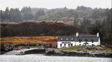  ??  ?? Paradise on earth: The boathouse cafe, which attracts around 5,000 visitors a year, is seen across the water on the Isle of Ulva, off Scotland’s west coast. (Left) Munro posing by the island shore.