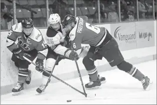  ?? Photo courtesy Tim Smith/The Brandon Sun ?? Evan Weinger (25) of the Brandon Wheat Kings tries to play the puck between Jordy Bellerive (15) and Ty Prefontain­e of the Lethbridge Hurricanes during the first period of game four of the WHL semifinals at Westoba Place on Wednesday evening.