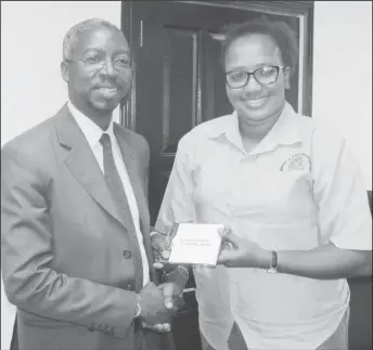  ?? (MPI photo) ?? Minister within the Ministry of Public Infrastruc­ture, Annette Ferguson (right) presents the Linden-Lethem Feasibilit­y Study to Idrissa Dia of the Islamic Developmen­t Bank.