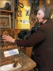  ?? TRACEY READ — THE NEWS-HERALD ?? Louise Jackson of the Geauga County Historical Society shows visitors shoe artifacts on display at The Leather Shop April 8. The Leather Shop is the newest historic building to open at Century Village Museum in Burton Township.