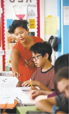  ??  ?? Math teacher Melanie Buntichai works with students in San Francisco. The city’s middle schools had gains in both math and English.