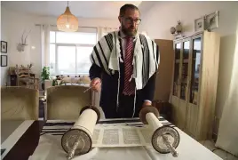  ?? JON GAMBRELL AP ?? Alex Peterfreun­d, a co-founder of Dubai’s Jewish community and its cantor, prepares to read from the Torah in Dubai, United Arab Emirates, on Aug. 16, 2020.