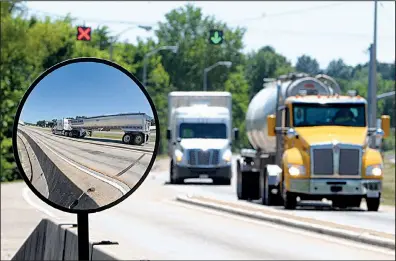  ?? NWA Democrat-Gazette/DAVID GOTTSCHALK ?? Commercial trucks pass through a weigh station on Interstate 40 near Van Buren earlier this month. The trucking industry faces an estimated shortage of about 50,000 drivers, according to American Trucking Associatio­ns data.