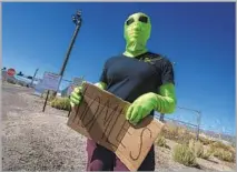  ?? Brian van der Brug Los Angeles Times ?? SHE COMES IN peace, we hope. An alien enthusiast who calls herself “Globus” watches the action at Area 51 near Rachel, Nev.