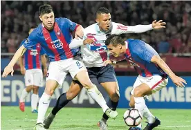  ?? EFE ?? James Sánchez intenta eludir la marca de dos jugadores del Cerro Porteño.