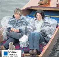  ??  ?? ®Ê SOGGY: Tourists brave the rain to go punting in Cambridge yesterday