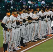  ?? ELAINE THOMPSON — THE ASSOCIATED PRESS ?? San Francisco Giants players watch as the Seattle Mariners are introduced before Thursday’s opening game.