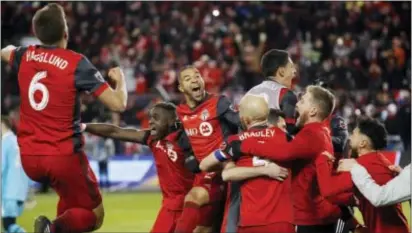  ?? MARK BLINCH/THE CANADIAN PRESS VIA AP ?? Toronto FC players celebrate a goal by midfielder Victor Vazquez (obscured) in stoppage time against the Seattle Sounders during Saturday’s MLS Cup match.