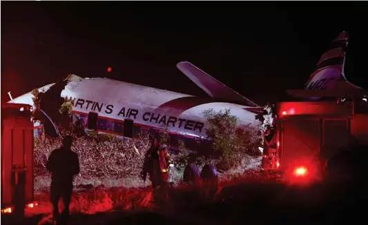  ??  ?? South African paramedics and emergency services gather at the scene of a plane crash on Tuesday at Wonderboom, on the outskirts of Pretoria, South Africa. Nineteen people were injured when a plane crashed in a grassy area of the South African capital.