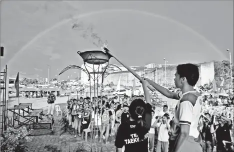  ?? PHOTO BY LOUIE LAPAT OF CIO TAGUM ?? PATRIO Reducto, a gold medalist in Sepak Takraw in the National Prisaa 2013, and Gerry Mei Amodia, a bronze medalist in Taekwondo in the Palarong Pambansa 2013, led the torch lighting during the opening ceremony of the 5th Summer Sports Festival at the...