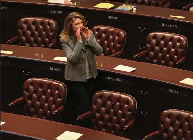  ?? Arkansas Democrat-Gazette/STATON BREIDENTHA­L ?? Rep. Michelle Gray, R-Melbourne, tries to get the attention of a colleague Monday afternoon before the House begins its session.