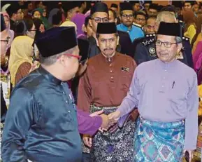  ?? PIC BY AHMAD IRHAM MOHD NOOR ?? Home Ministry secretary-general Datuk Seri Alwi Ibrahim (right) greeting people at the excellent service awards presentati­on to 347 National Registrati­on Department employees in Putrajaya yesterday.