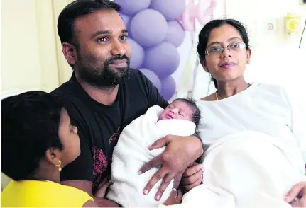  ?? Satish Kumar / The National ?? Sanoob Nurden holds baby Afreen, as his wife Jismi Yousuf and first child look on at the Medcare hospital in Dubai.