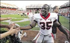  ?? AJC FILE ?? As a Georgia linebacker, Rennie Curran celebrates with fans as he leaves the field following a 14-7 road victory over South Carolina on Sept. 13, 2008. As a sophomore, he led the Dogs in tackles and sacks.