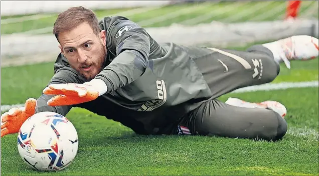  ??  ?? Oblak, el Zamora de Primera, hace una estirada durante un ejercicio del entrenamie­nto del Atlético.