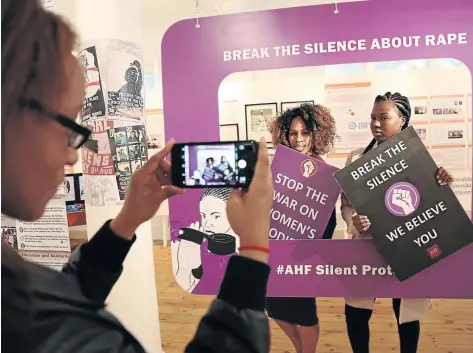  ?? / JACKIE CLAUSEN ?? Josique Samuels takes a photo of Bongeka Ndebele and Nosisa Dlomo at the “Breaking the chains of Gender-Based Violence” exhibition which opens at KwaMuhle Museum in Durban today. The exhibition will mark the start of 16 Days of Activism to end violence...