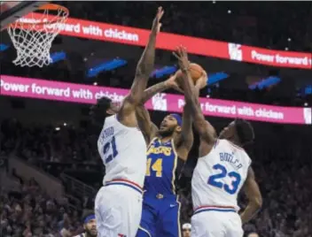  ?? CHRIS SZAGOLA – THE ASSOCIATED PRESS ?? Joel Embiid, left, the one and only crown jewel of the talented Sixers according to head coach Brett Brown, bodies up Sunday on the Lakers’ Brandon Ingram, center, with some help from Jimmy Butler.