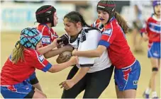  ??  ?? Oakey player Rochelle Robinson hangs onto the ball while tackled by three Warwick defenders.