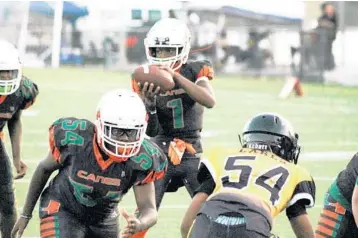  ?? PHOTOS BY EMMETT HALL/CORRESPOND­ENT ?? Above, Fort Lauderdale Hurricanes quarterbac­k Keyone Jenkins, 12, takes the snap and runs for a touchdown in a Florida Youth Football League first-round playoff victory over Lauderdale Lakes. Right, Hurricanes running back Jayvant Brown, 13, cuts...