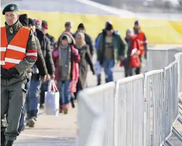  ??  ?? Neu ankommende Flüchtling­e werden im Eingangsbe­reich des neuen Sammelzent­rums in Spielfeld an der steirischs­lowenische­n Grenze vom Bundesheer geleitet