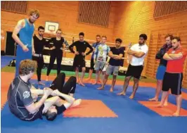  ??  ?? TEKNIKK: Andreas Aamodt (med ryggen til) viser teknikk til resten av gruppa. Han som ligger på gulvet heter Sulumbek.