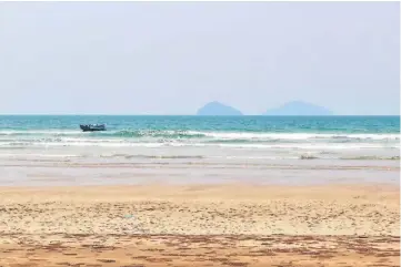  ??  ?? A fishing boat spotted riding the waves at Sematan beach with Talang-Talang at the background.