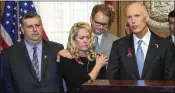  ?? MARK WALLHEISER / ASSOCIATED PRESS ?? Tony Montalto (left) and his wife, Jennifer, parents of victim Gina Montalto, 14, and Ryan Petty, father of victim Alaina Petty, 14, comfort one another Friday before Gov. Rick Scott signs the school-safety gun-control bill Friday in Tallahasse­e.