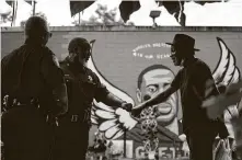  ?? Marie D. De Jesús / Staff photograph­er ?? Harris County Sheriff ’s Deputy Anthony Glenn fist-bumps a Third Ward resident Monday in front of the George Floyd mural.