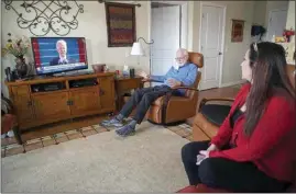  ?? ALLEN G. BREED / AP ?? Democrat Jim Carpenter, left, and Republican Natalie Abbas watch the inaugurati­on of President Joe Biden in Carpenter’s apartment in Frederick, Md., on Jan. 20.