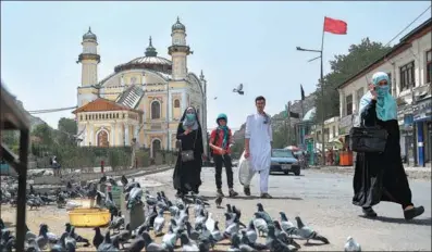  ?? HOSHANG HASHIMI / AFP ?? People walk past the Shah-Do Shamshira Mosque in Kabul on Wednesday following the Taliban’s rapid takeover of Afghanista­n. The Taliban leadership says it wants good relations with foreign countries in order to revive its economy and ensure prosperity.