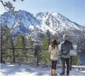  ?? MIKE NELSON, EUROPEAN PRESSPHOTO AGENCY ?? In April, visitors view Lake Tahoe’s snow-covered Sierra Nevada. Record snowfall made the winter the area’s wettest since records started being kept nearly a century ago. There’s still plenty up there.