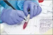  ??  ?? A health worker records a sample taken for testing for Covid-19 on the outskirt of Agartala on Tuesday. ANI