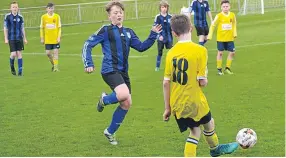  ??  ?? A Ferry U/13s player (yellow) attempts to thread a ball through to a teammate in the Diamond Jubilee Cup Final defeat against Forfar.