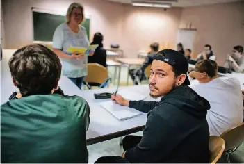  ?? RP-FOTO: RALPH MATZERATH ?? Vinicius (Mitte) bereitet mit anderen Schülern seinen Realschula­bschluss bei der Volkshochs­chule Monheim vor. Neben Schulabsch­lüssen stehen unter „Ausbildung“auch Integratio­n und Berufsvorb­ereitung im Programm.