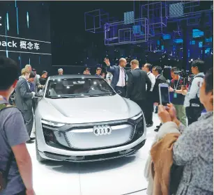  ?? (Aly Song/Reuters) ?? PEOPLE GATHER around the Audi e-tron Sportback concept car at the Shanghai Auto Show in April.