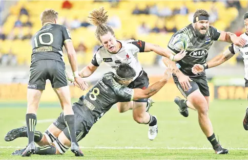  ?? — AFP photo ?? Sunwolves’ Michael Little (C) is tackled by Hurricanes’ Brad Shields and Beauden Barrett (L) during the Super Rugby match between the Wellington Hurricanes of New Zealand and the Sunwolves of Japan at Westpac Stadium in Wellington on April 27, 2018.