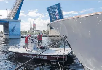  ?? JOE CAVARETTA/STAFF PHOTOGRAPH­ER ?? A crew from TowBoat U.S. prepares to help the yacht Checkmate as it gets underway at the Las Olas Marina.