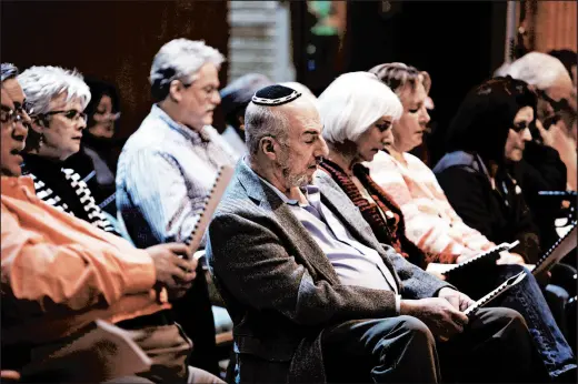  ?? SUZANNE TENNANT/POST-TRIBUNE PHOTOS ?? Various members of the community sing together Friday at an interfaith Shabbat/vigil at Temple Israel in Gary in honor of the victims of the Pittsburgh massacre.