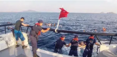  ?? Agence France-presse ?? ↑ Turkish coastguard rescue illegal migrants after their boat sank in the Aegean sea off the coast of southweste­rn Turkey on Monday.