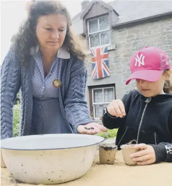  ??  ?? Grace Kelly, seven, planting seeds to be grown in the farm garden to help the wartime effort.